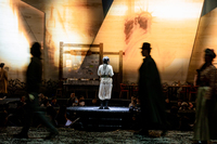The silhouettes of characters such as Chance (Yang Zhibin) and Pema (Hao Lei) circle around the audience, while Dorje (Zhang Jie) stands on the center platform.