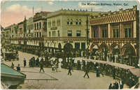 A crowded boardwalk with architecture meant to imitate the Doge’s Palace and palazzi in Venice. A miniature railway curves around in the foreground with passengers riding on it. The word VENICE is mounted in lights in giant letters on the left.
