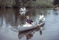A color photograph of Gaylord Nelson and others paddling aluminum canoes.