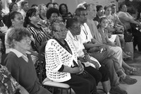 Photograph of Dona Hilda sitting in the audience of a Codespa meeting.