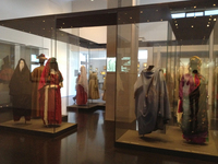 Display view of mannequins behind glass adorned with traditional Mizrahi attire in the Judaica and Jewish Ethnography Wing, the Israel Museum.