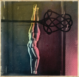 The hand-tinted black and white photograph from The Games of the Doll series (1938-1949) by Hans Bellmer depicts the four-legged doll pinned against a doorframe, while a large rug beater looms in the foreground. The naked doll, legs clad in white socks, offers its amorphous body, two pelvises and buttocks, to the viewer for punishment