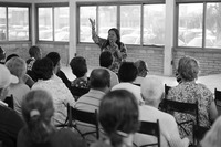 Photograph of Benedita speaking in the microphone during Codespa meetings.