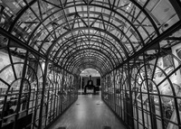 A hallway with glass walls and a glass archway allows the viewer to see items from the exhibition on either side.