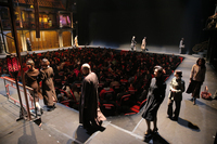 Performers circle the audience members, who are seated on swivel chairs in the center pit, commonly known as the Lotus Pond.