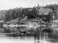 A black-and-white photograph of the Hotel Ampersand, looming over Lower Saranac Lake in the Adirondacks ca. 1890.