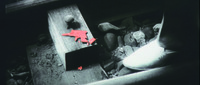 An Icon of the Genre: The gun “triply emphasized” by film style: in a harsh monochromatic close-­up, we see the gleaming white shoe of Tetsu protruding from right of screen, while just off-­center, on the railroad track, we see a toy gun, broken into pieces and with each piece glowing red, in a display of non-­diegetic color stylization.