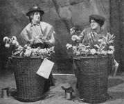 Costumed as Cockney flower sellers, Douglas Byng, in drag, and Hermione Baddeley perform.